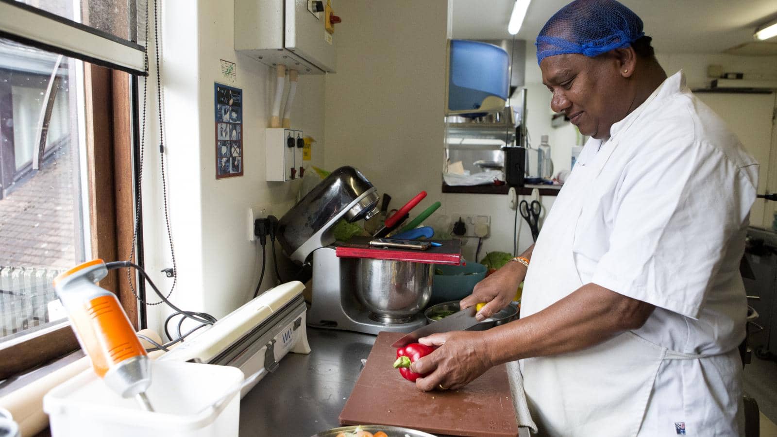 Chef preparing food at a chopping board in a kitchen