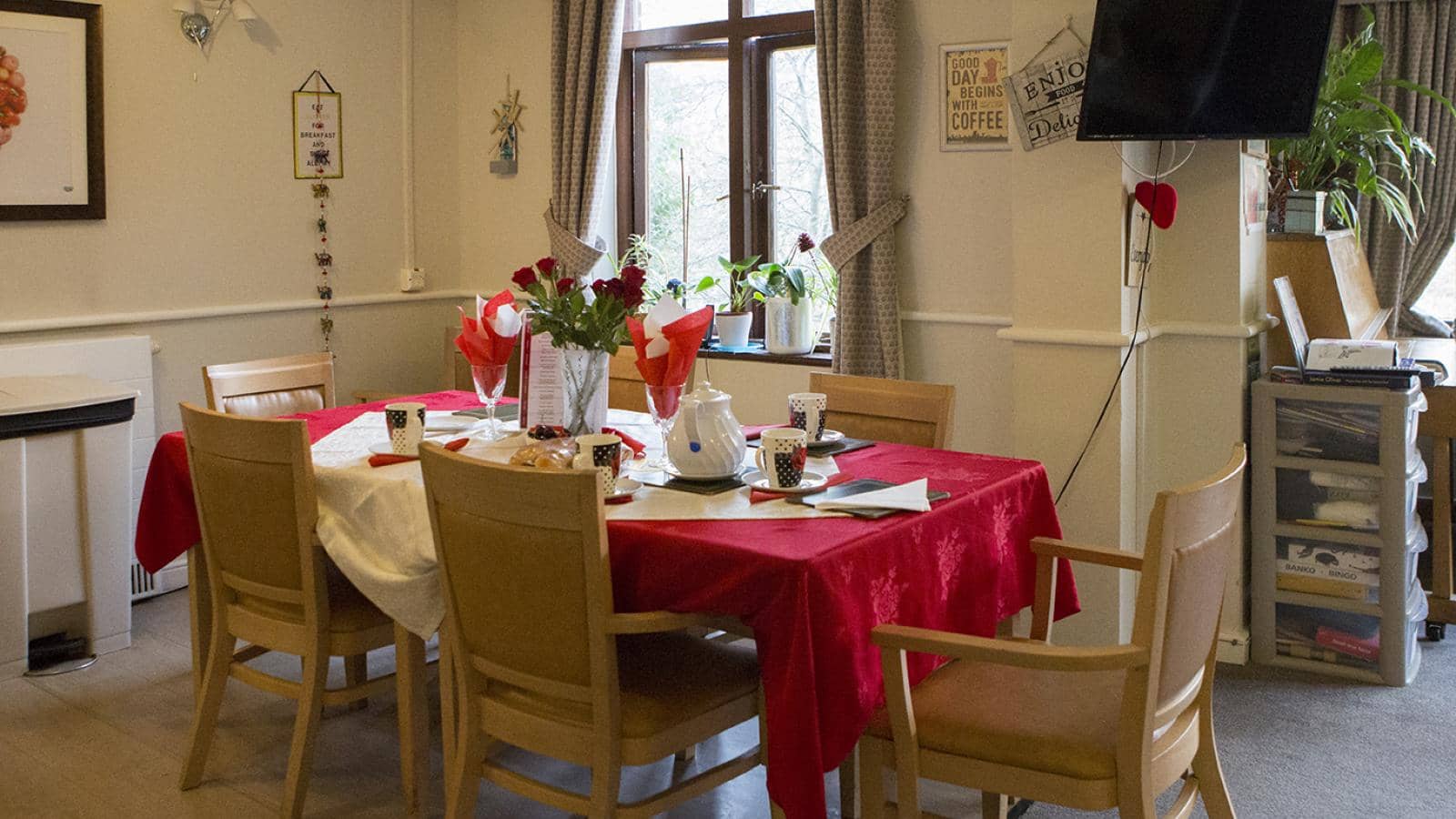 Decorated dining table set for six people in a care home dining rooom