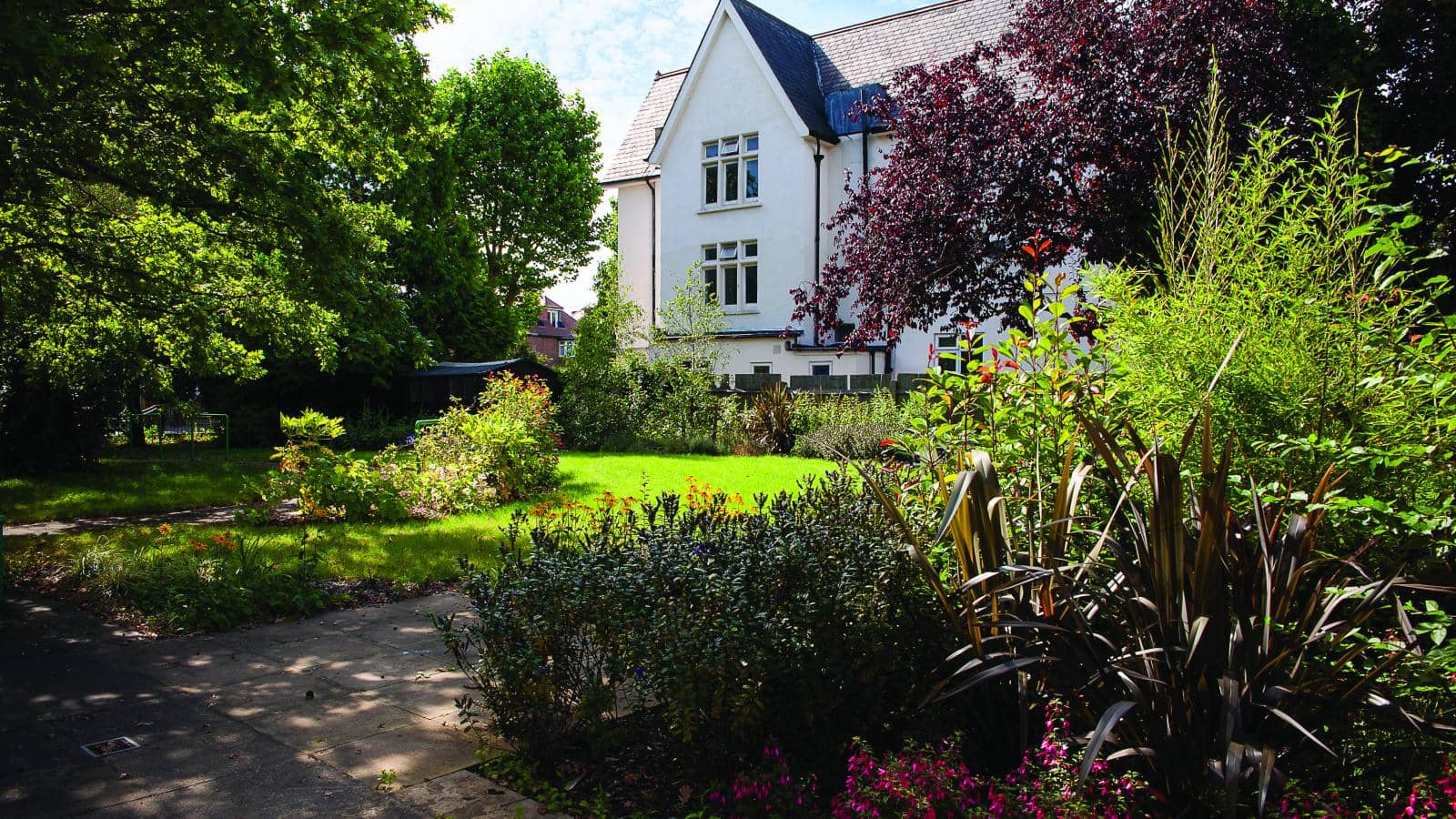 The rear gardens of a care home in the summer in sunshine