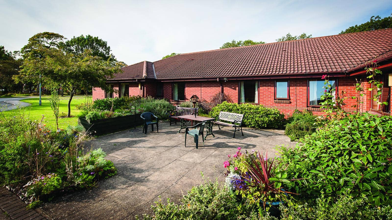 MHA Warde Aldam care home patio and gardens on a sunny afternoon