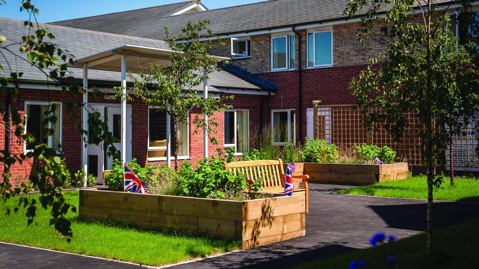 MHA Waterside House care home patio and raised flowerbeds and park bench