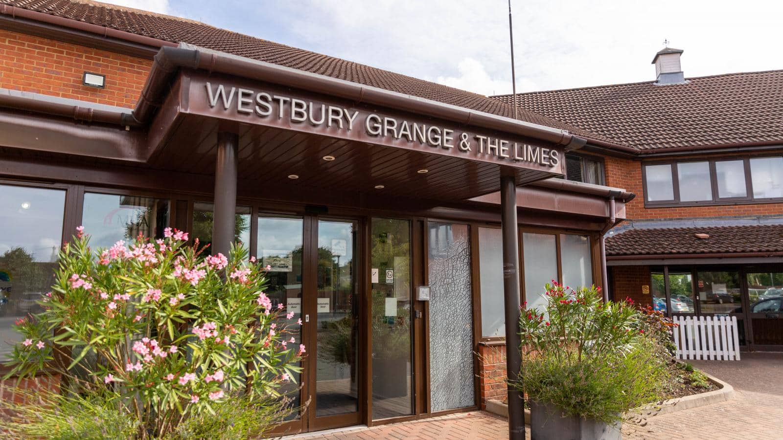 Main entrance and reception of Westbury Grange care home with flowers and signage