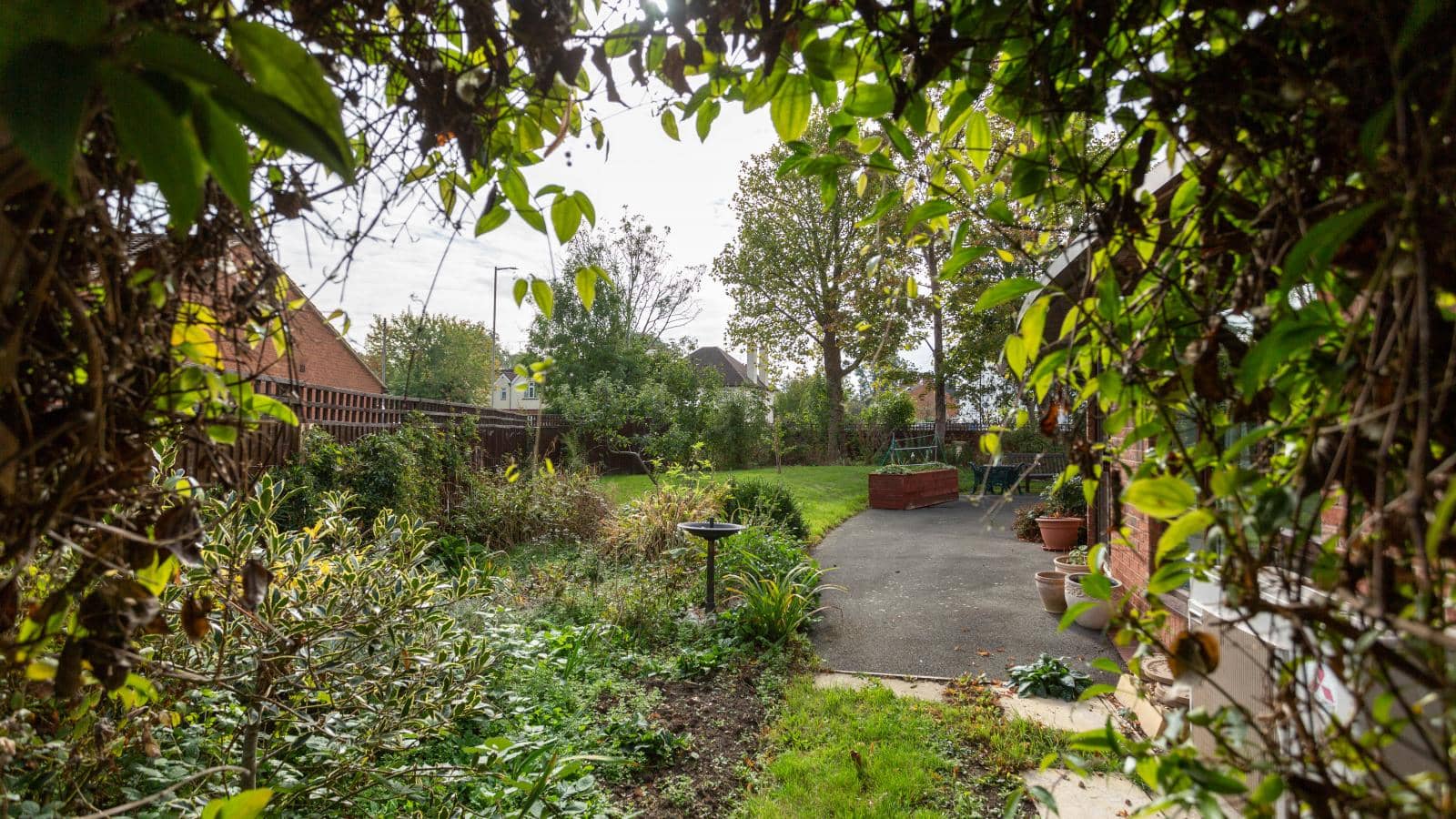 Gardens, bushes and trees of Westbury Grange care home on a cloudy day