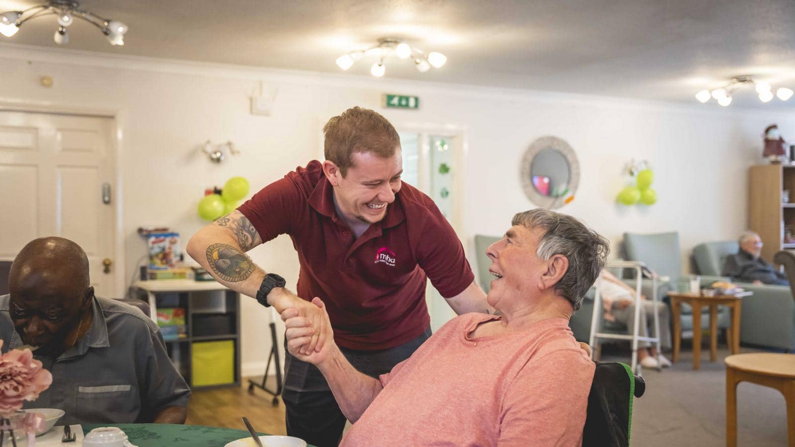 A male activities coordinator shakes hands with a male resident.