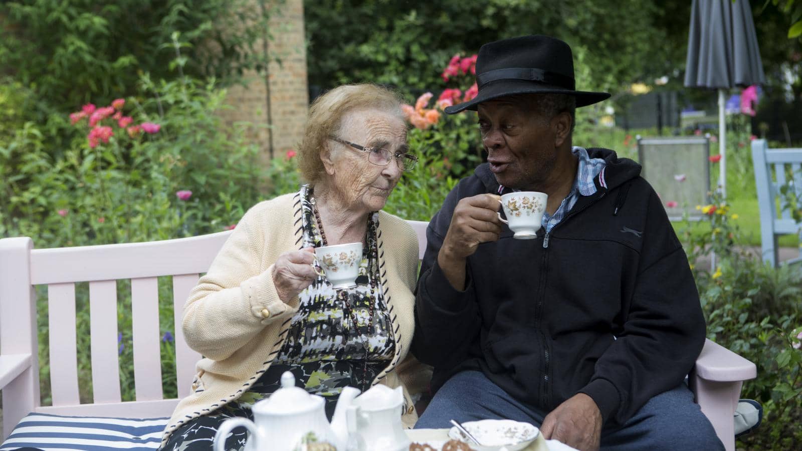 Two residents have a cup of tea in the garden