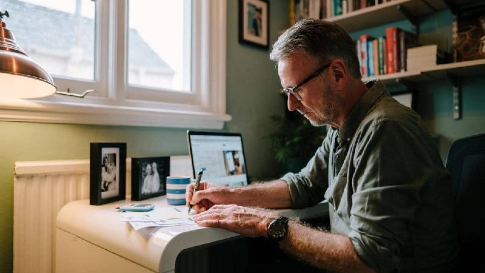 Man sits down at a desk doing paperwork