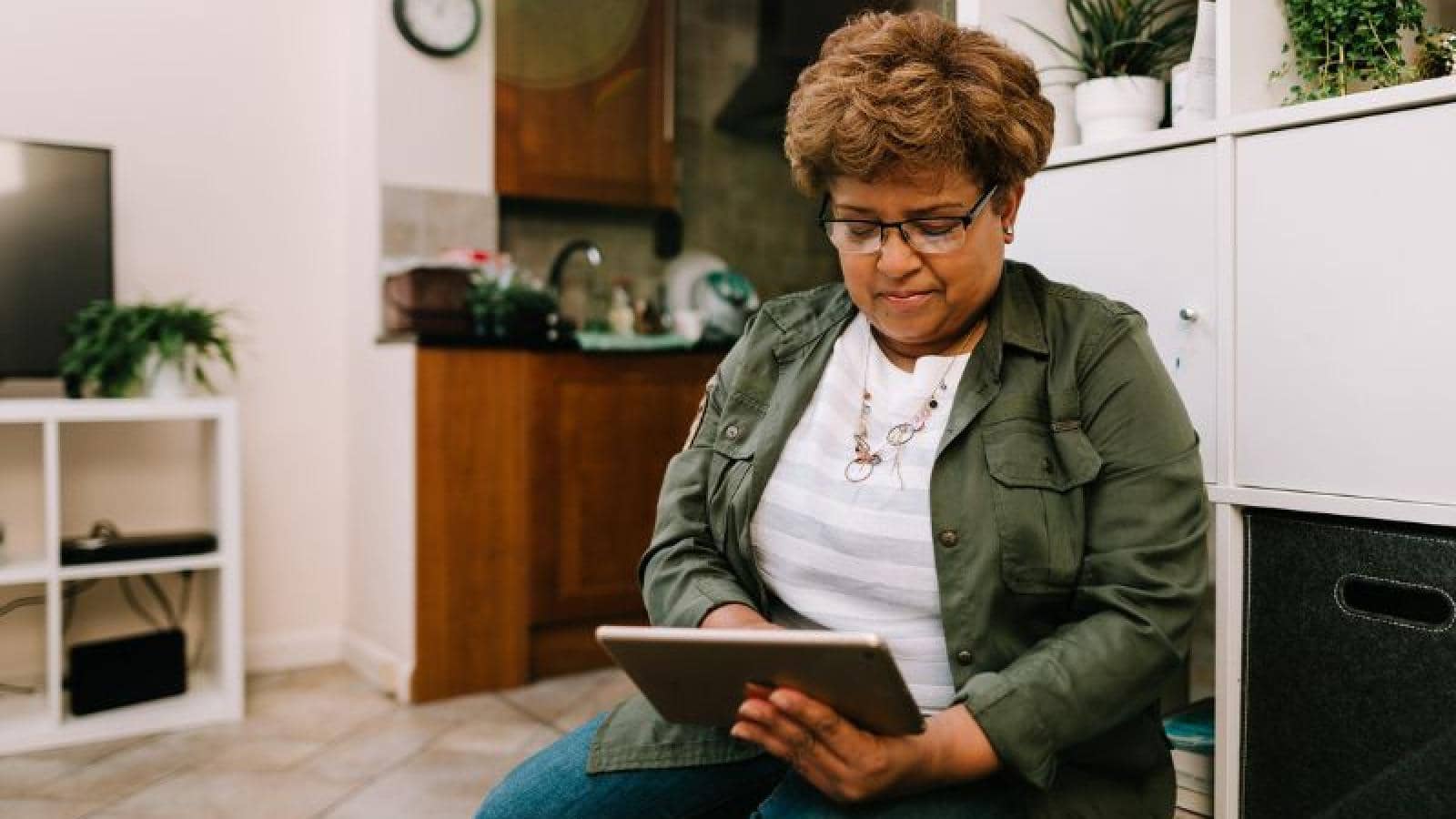 Woman sits down looking at her digital tablet