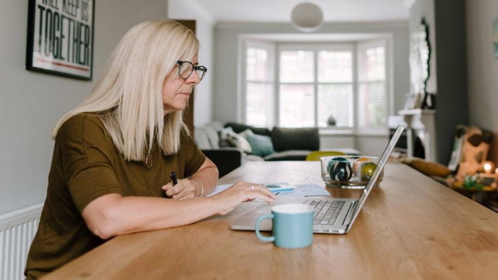 A women sits at a table on a laptop