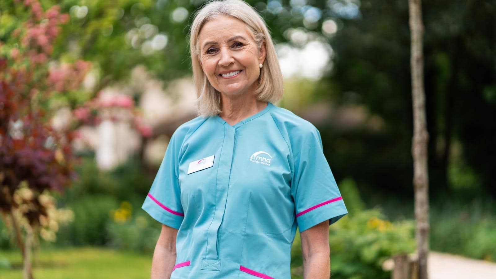 Female care assistant posing for a photo in the garden