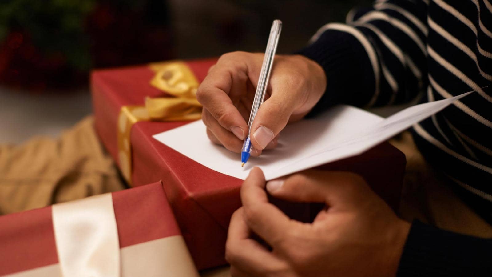 male hands writing christmas greetings card