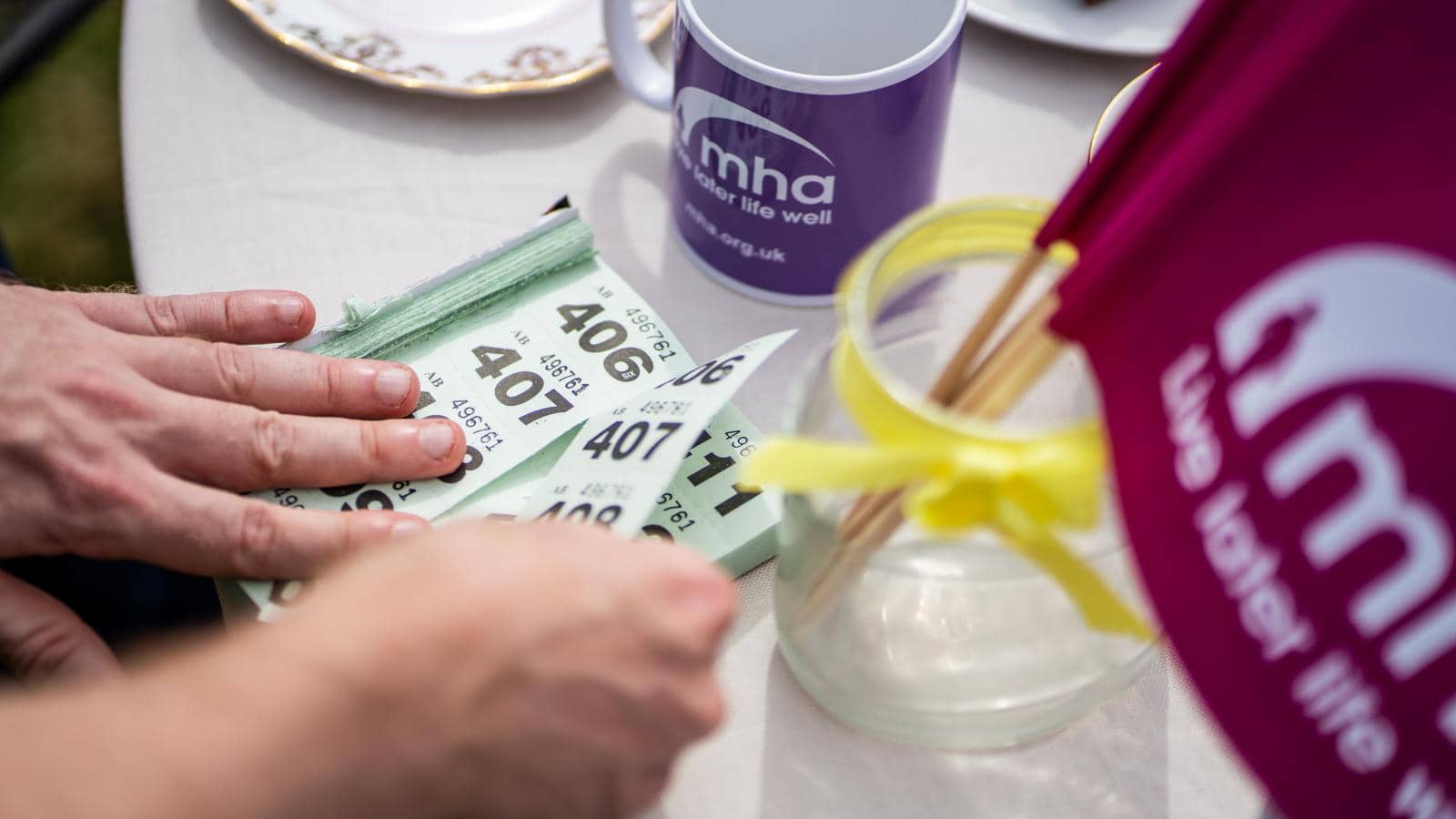  close-up of a table setting where a person is handling a stack of bingo cards