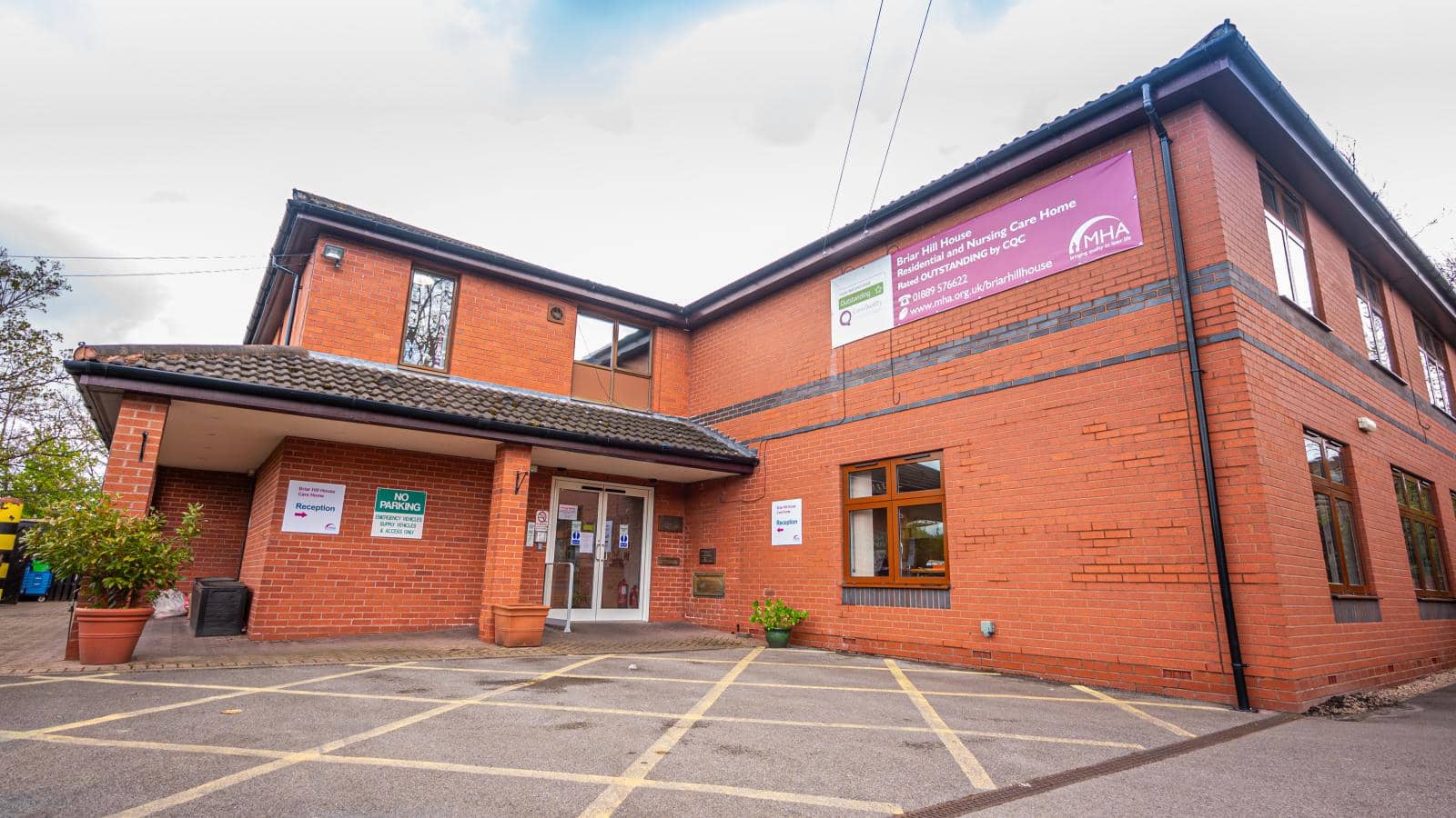 The image depicts a modern brick building with a flat roof - Briar Hill House