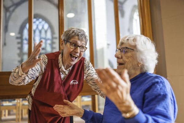 Community Coordinator/volunteer and member dancing at a Zumba session