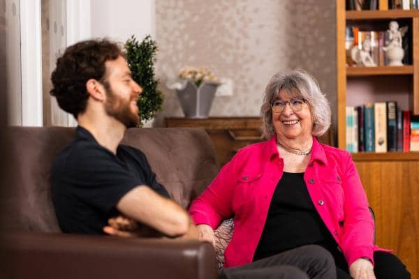 Two friends seated on a sofa having a conversation