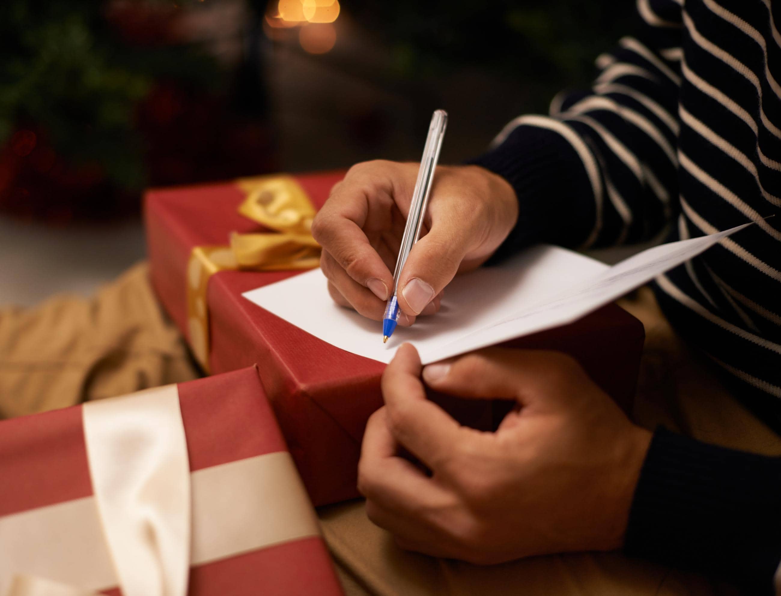 male hands writing christmas greetings card