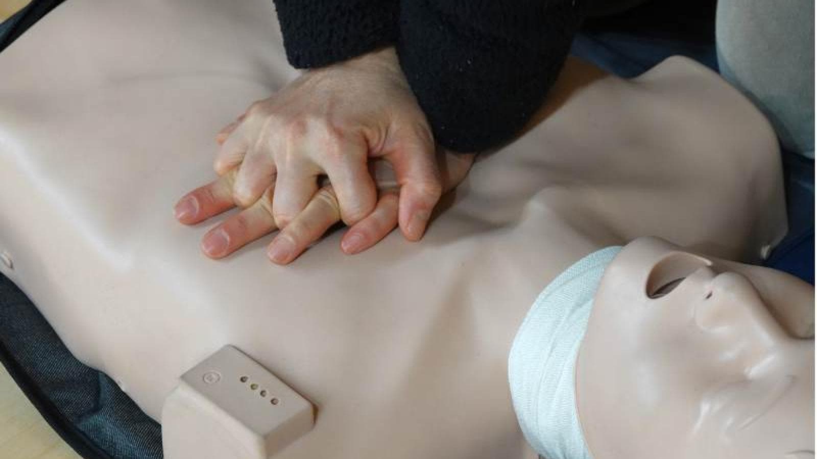 Someone practices CPR on a safety dummy. 
