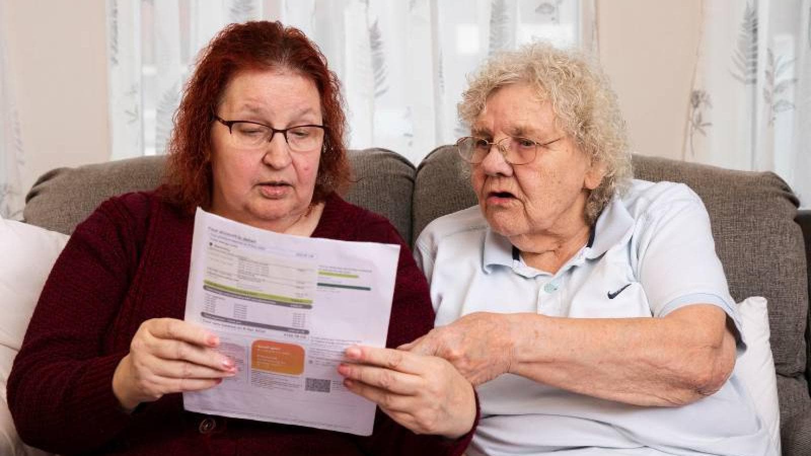 Two women are talking about some paperwork.