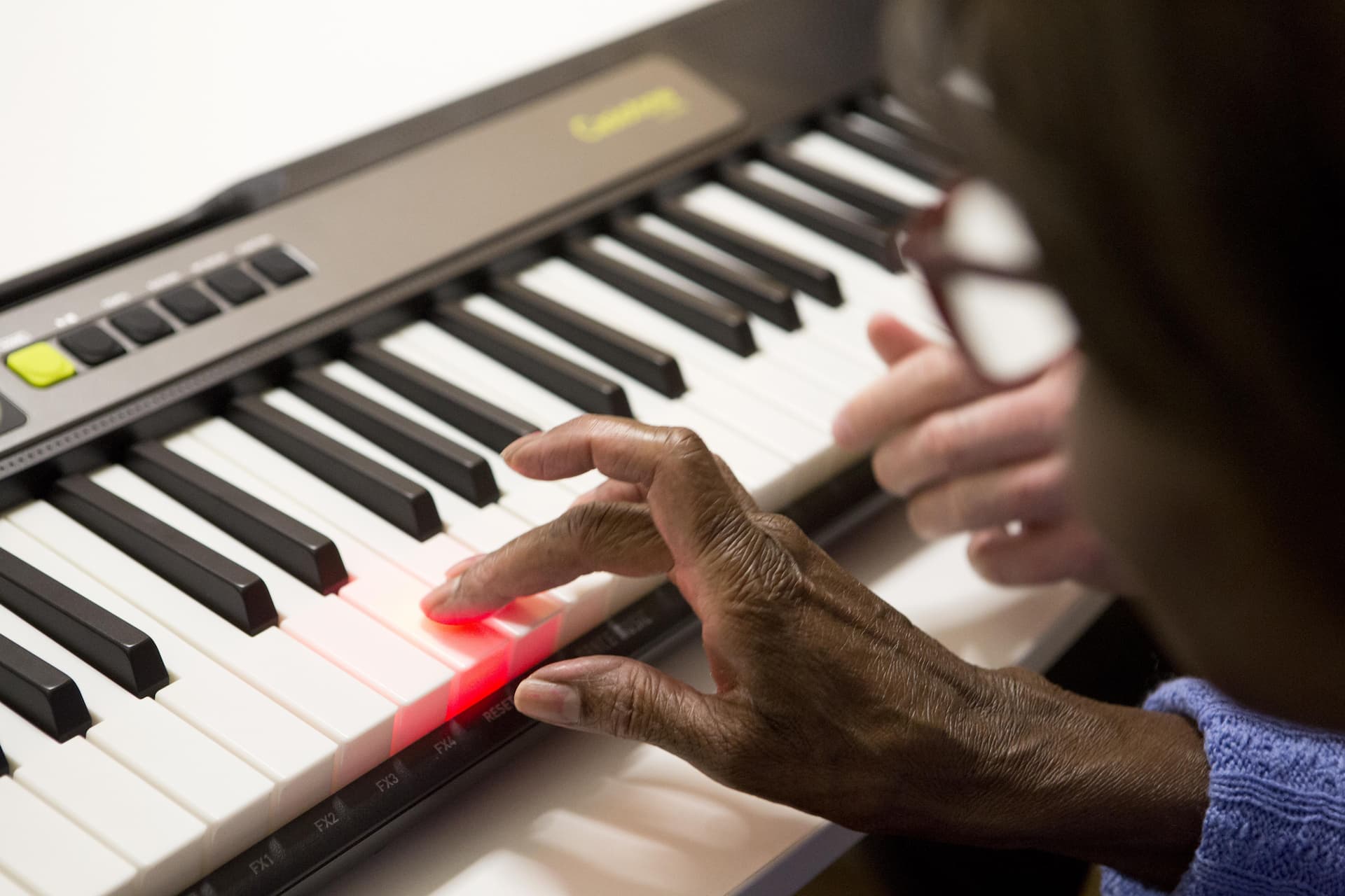 Woman plays a note on the Casio keyboard and the key lights up